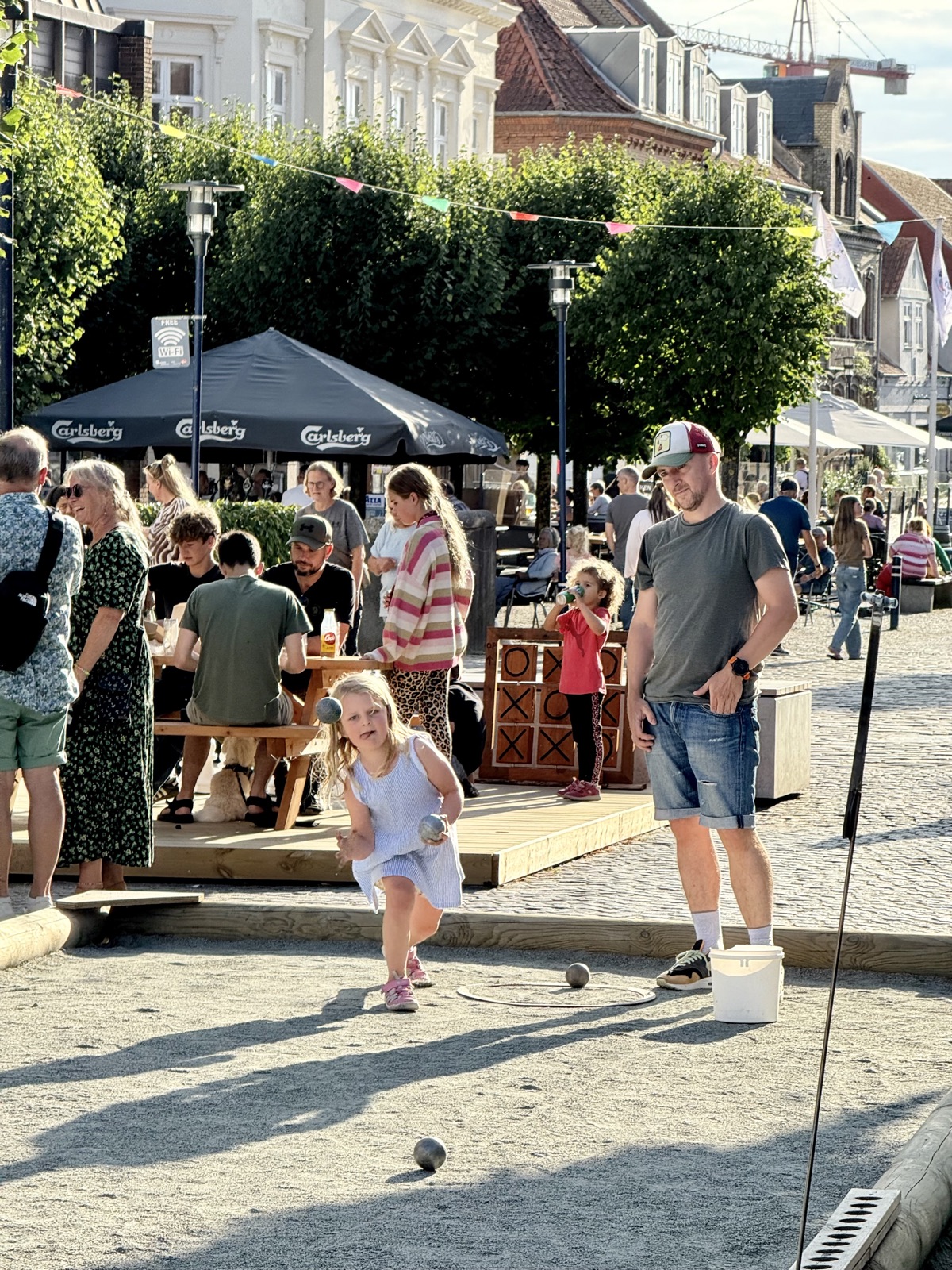 Sommerliv med petanque og leg på torvet i Assens
